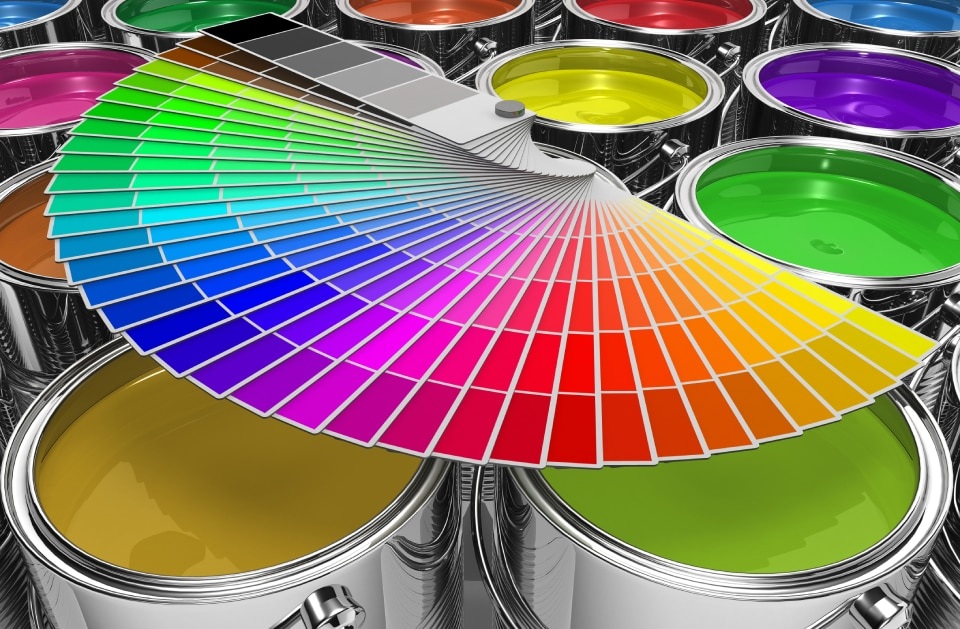Latas de pintura de colores vibrantes con abanico de muestras de color